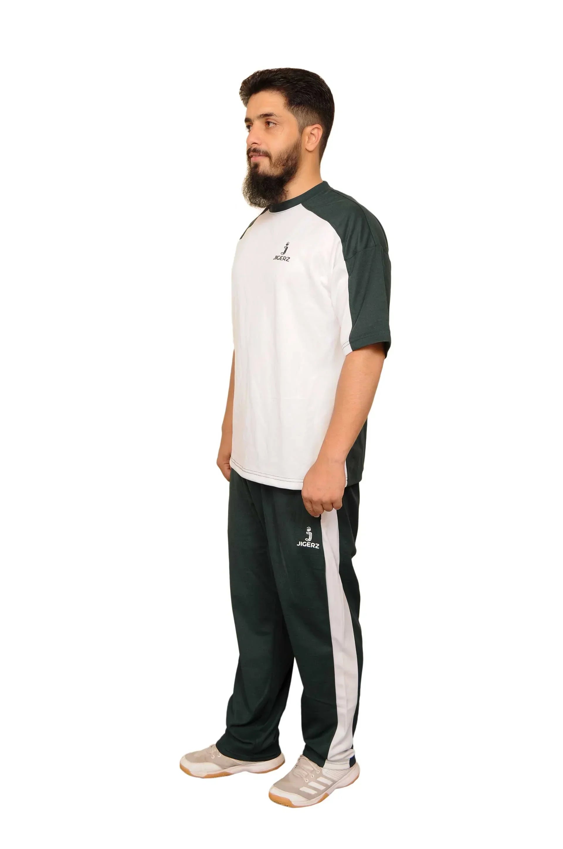 Man wearing black and white Jigerz tracksuit with white sneakers on white background