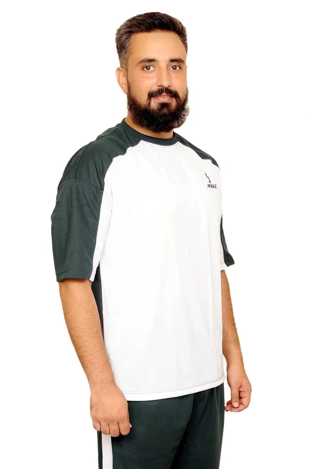 Man wearing black and white sportswear with sneakers standing on white background