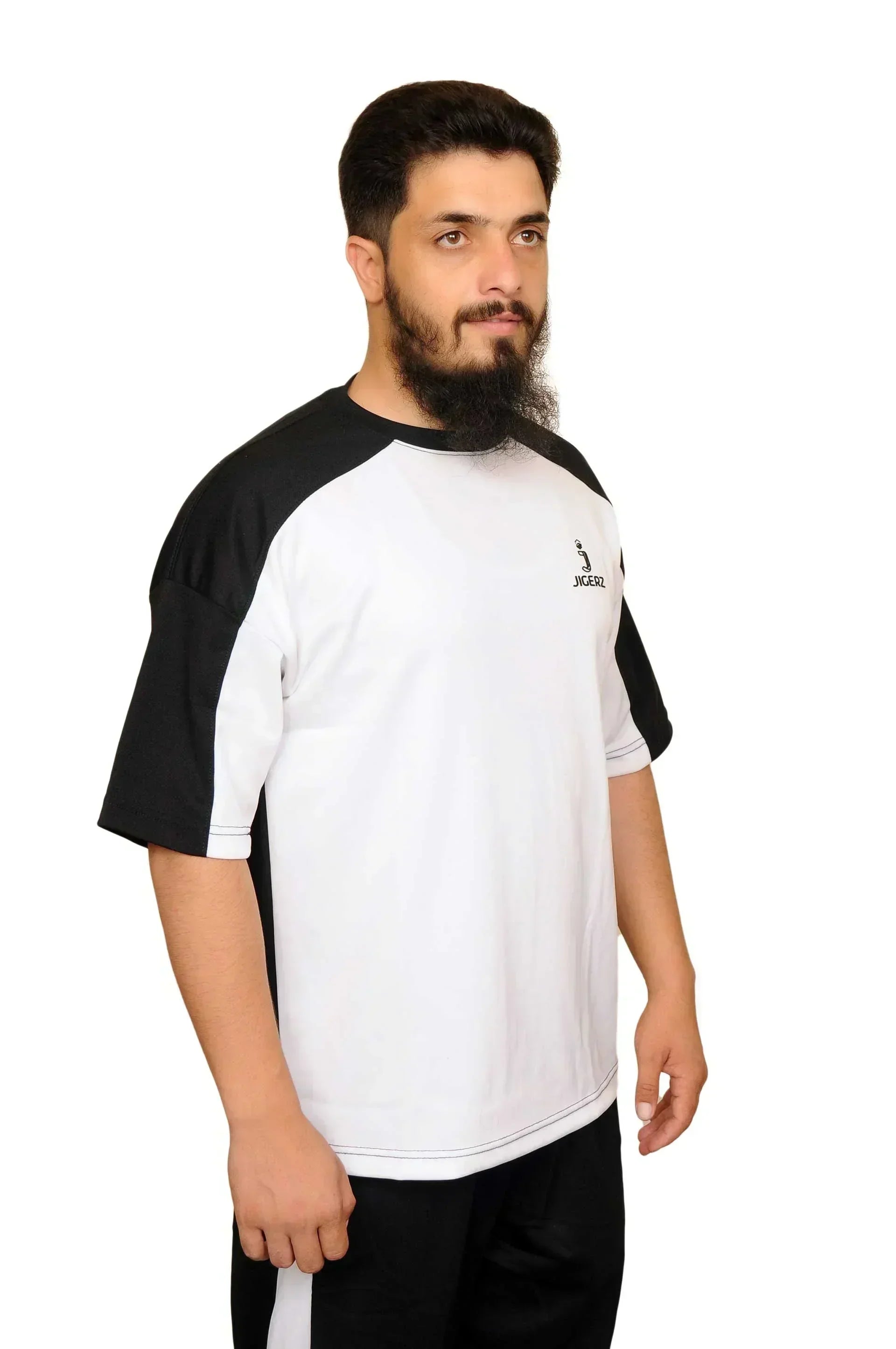 Man with beard wearing black and white Jigerz sports t-shirt standing against white background