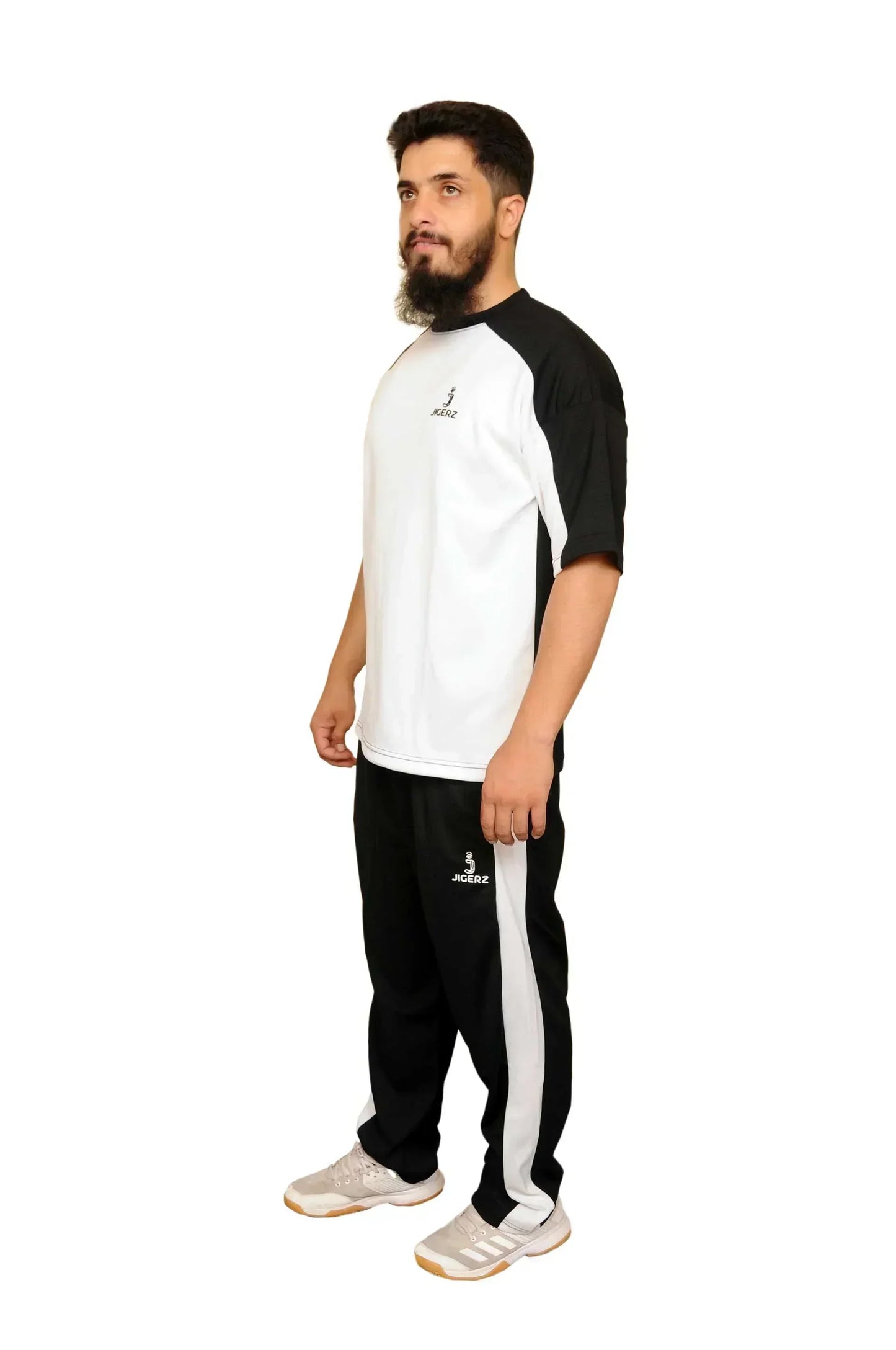 Man modeling black and white Jigerz sportswear set with white sneakers on white background