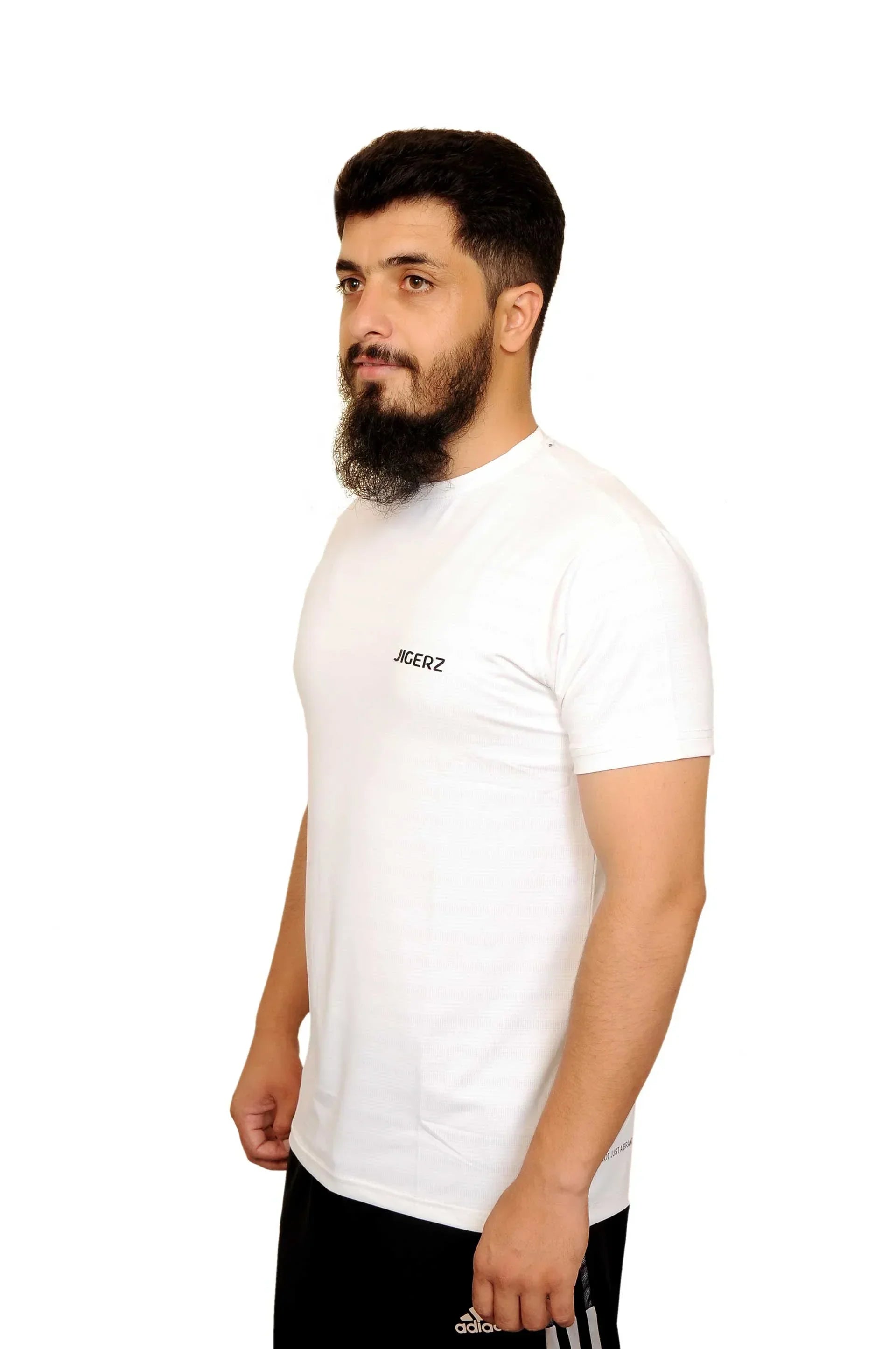 Man with beard wearing white Jigerz t-shirt and black Adidas shorts against white background